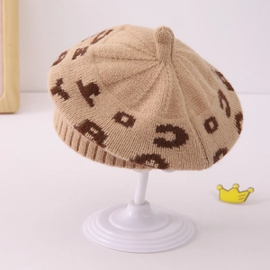 Close-up of beige leopard pattern jacquard knit beret with ribbed edge and soft texture