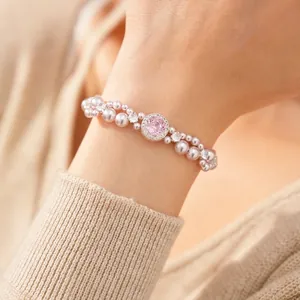 Elegant double-layer pearl bracelet with a pink zircon centerpiece on a woman's wrist