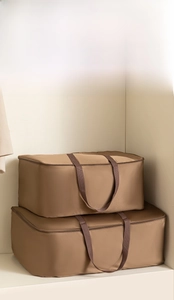 Vertical stack of deep brown thick satin storage bags for seasonal bedding and clothes