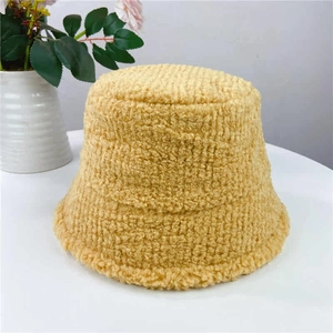 Detailed texture of ginger yellow lamb wool bucket hat with soft plush grainy finish