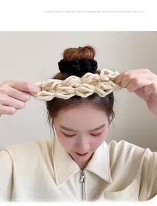 Detailed view of cream-colored knit headband and black scrunchie on model