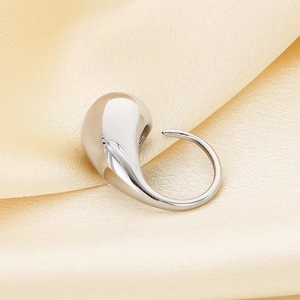 Polished silver teardrop ring shown on champagne satin fabric with reflective finish
