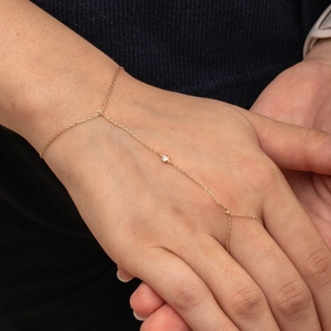 Macro view of 18k gold plated stainless steel hand chain with round zircon on female hands