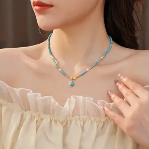 Collier turquoise plaqué or avec pendentif cœur et perles porté par un mannequin