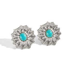 Detailed close-up of silver earrings with sunburst pattern and oval turquoise gemstone