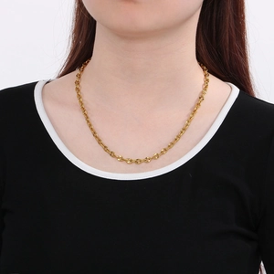 Close-up of a 6mm gold stainless steel link necklace worn on a black sweater neck