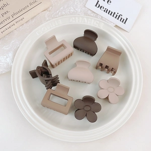 Detail of matte brown and beige small hair claw clips in square and flower shapes