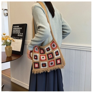 Detail of bohemian knit tote bag showing khaki color and handmade fringe tassels