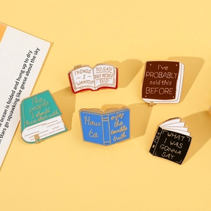 Flat lay of five colorful enamel book pins with creative English quotes on yellow background
