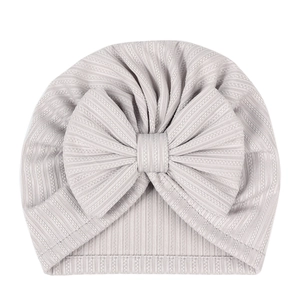 Detail of light grey ribbed knit fabric and large bow on baby turban hat