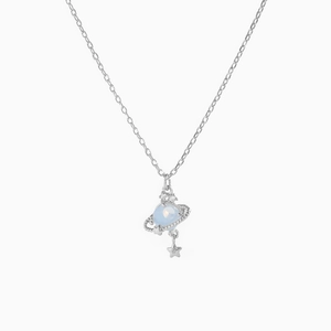 Close-up of silver Saturn planet pendant with light blue orb and sparkling zircon stones