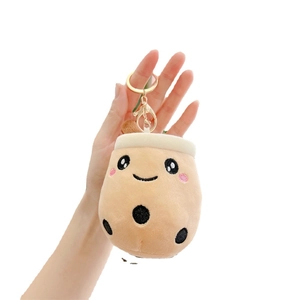 Plush bubble tea cup keychain featuring a cute smile and black pearls on a soft fabric