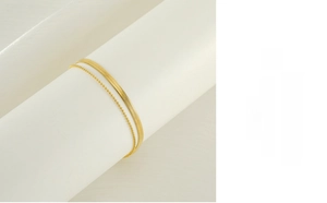 Detail of 18K gold plated double layer anklet featuring flat snake and bead chains