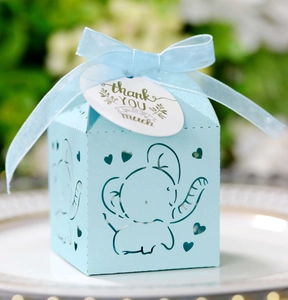 Close-up of light blue baby elephant favor box with laser-cut heart and ribbon bow