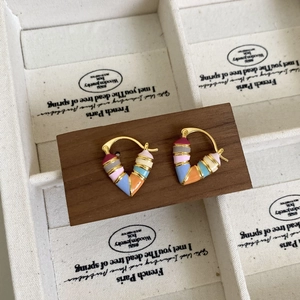 Détail de créoles en forme de V en émail coloré avec base en métal doré et boucle d'oreille