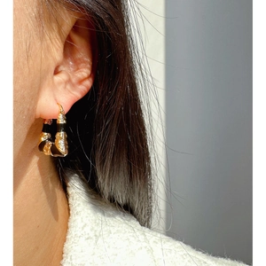 Abstract geometric trapezoid hoop earrings with gold-tone metal and black enamel texture