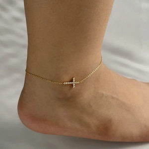 Elegant gold stainless steel anklet with a sparkling zircon inlaid cross on a model