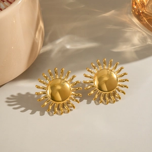 Gros plan détaillé des boucles d'oreilles soleil en finition or 18 carats polie