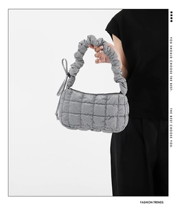 Detail of silver ruched handle and quilted texture on a trendy cloud-shaped handbag