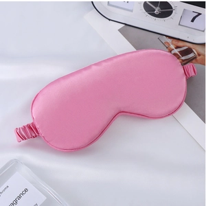 Detailed view of a soft pink satin sleep mask with elastic strap for travel and home
