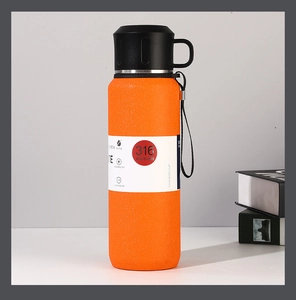 Detail view of orange matte 316 stainless steel vacuum insulated bottle with carrying strap