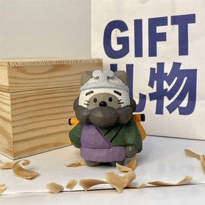 Detailed close-up of hand-carved wooden cat figure with kimono in premium gift packaging