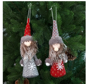 Close-up of knit Christmas gnome ornaments with long beards hanging on a festive tree branch