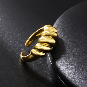 Macro shot of gold croissant ring featuring a spiral twisted design on black leather