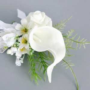 Elegant white Calla Lily wedding boutonniere with green leaves and silk ribbon decoration