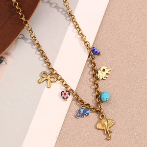 Detail of 18K gold-plated bracelet with elephant charms and colorful beads on soft fabric