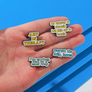 Set of four trendy enamel pins with English slogans featuring yellow and blue text