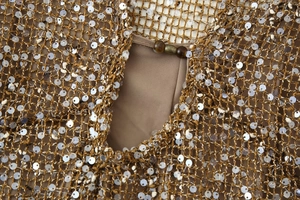 Vue détaillée de la robe en maille dorée avec paillettes argentées et perles