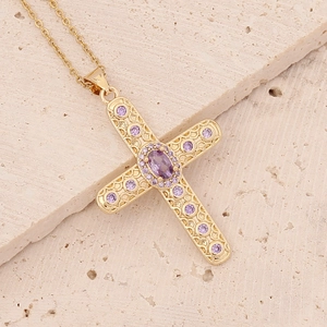 Close-up of 18K gold cross pendant featuring micro-set purple zircon and filigree details