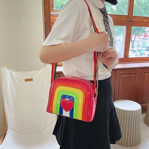 Detail of rainbow striped crossbody bag with a 3D red heart and wide colorful strap