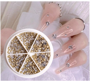 Close-up of sparkling nail art rhinestones and metal studs in a clear storage box