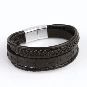 Detail of multilayer leather bracelet featuring cross embossing and a silver magnetic clasp