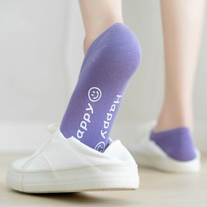 Detail of purple cotton low-cut socks featuring a happy face and silicone anti-slip heel
