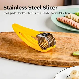 Manual stainless steel banana slicer with ergonomic yellow handle on a wooden board