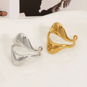 Detailed view of irregular organic gold and silver rings on white textured surface
