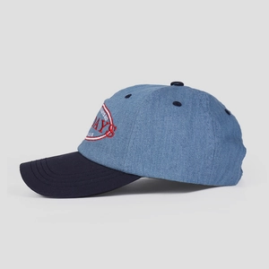 Detail of blue denim baseball cap showing red DAYS embroidery and stitched eyelets