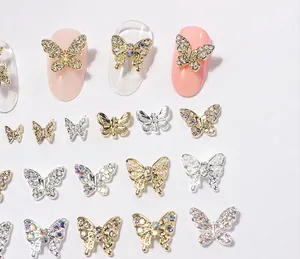 Detailed view of 3D metal butterfly nail charms with micro-paved rhinestones and pearls