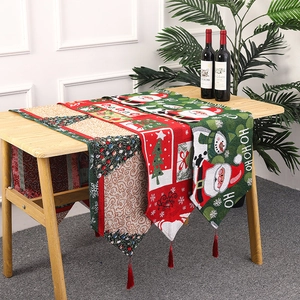 Detailed close-up of knitted Christmas table runners with Santa motifs and red tassels