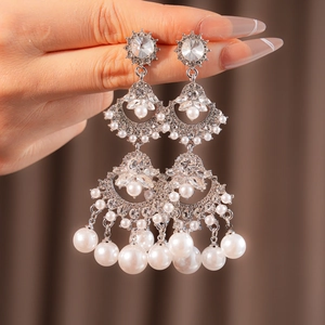 Detail of luxury fan-shaped tassel earrings with silver rhinestones and pearls