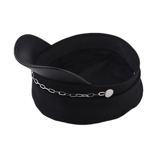 Détail d'une casquette gavroche noire avec chaîne argentée et visière en similicuir