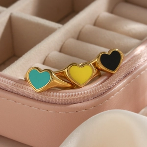 Detailed close-up of heart-shaped gold rings with colorful black and yellow enamel
