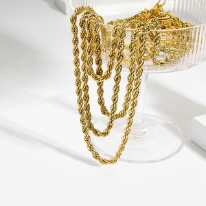 Detail of 18K gold-plated stainless steel rope chains hanging on a glass container