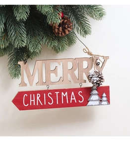 Détail d'une plaque Merry Christmas en bois sur des branches de sapin vert