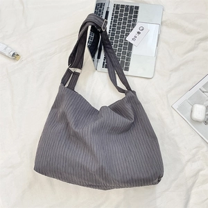 Macro view of dark grey pleated canvas bag with adjustable strap and silver buckle detail
