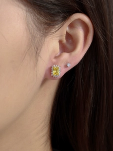 Macro view of gold vintage halo earrings with rectangle yellow gemstones and studs