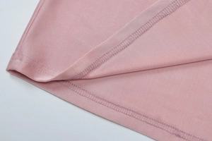 Dettaglio dell'abito in maglia rosa con cuciture ad alta densità e finitura dell'orlo